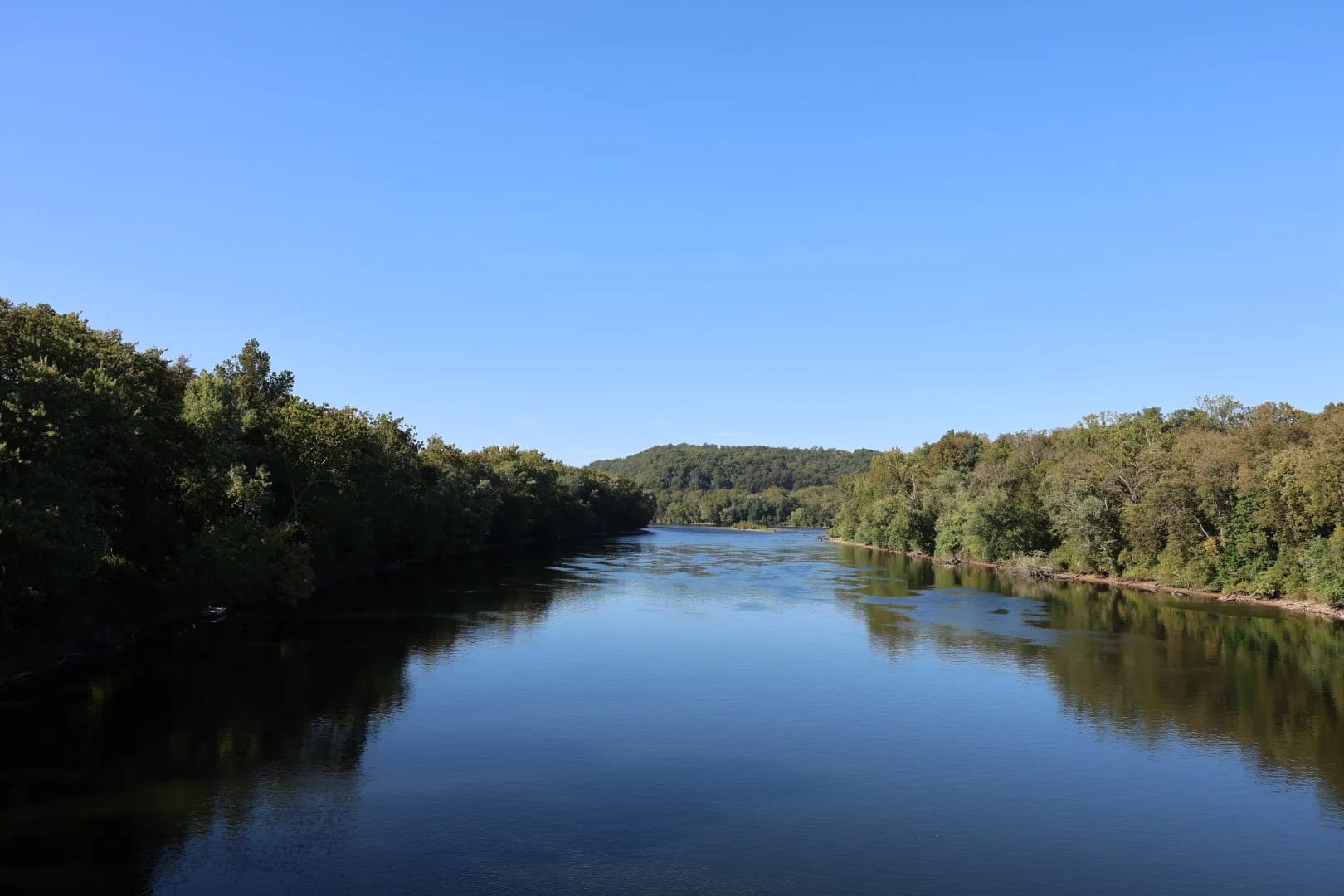 River winding through green hills under a clear blue sky